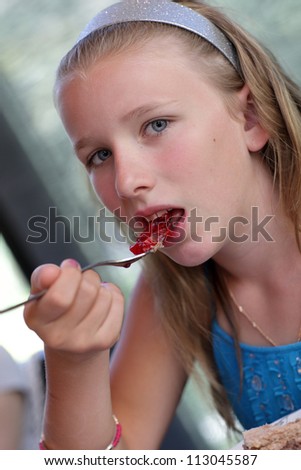 Girl is eating jam at the restaurant