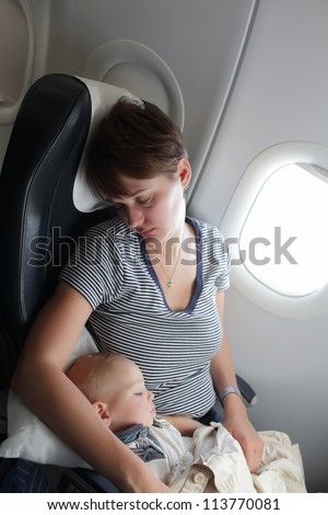 Woman with baby are sleeping on the flight Woman with baby are sleeping on the flight