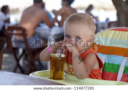 Child is drinking apple juice in a cafe