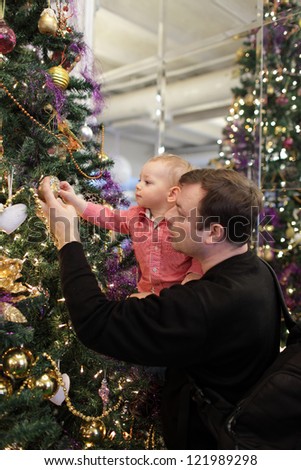 Father with son near Christmas tree at home