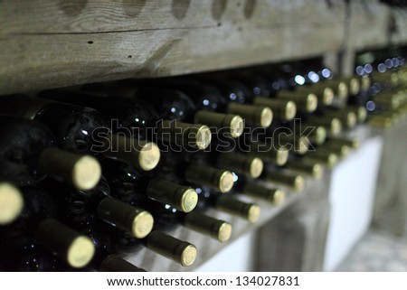 Old bottles of wine on a wooden shelf in cellar, Kakheti, Georgia