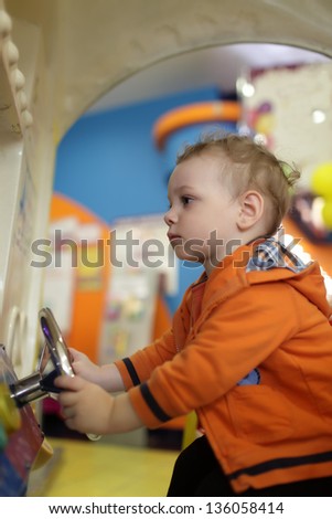 Toddler and amusement car at indoor playground