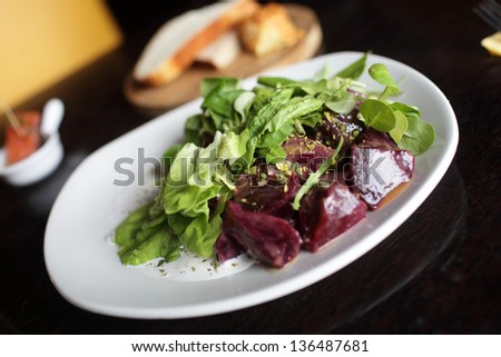 Roasted beets with lettuce on a white plate