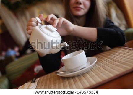 Girl is pouring green tea in the restaurant