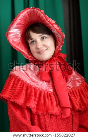 Girl is posing in a red historical clothing