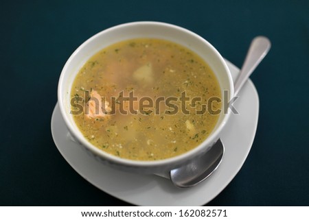 White plate of salmon soup on a table