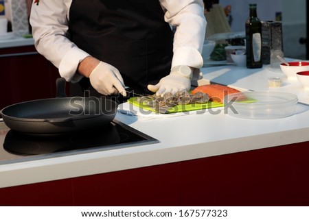 Chef cooking shrimps at a red kitchen