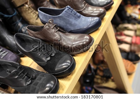 Mens shoes on the wooden shelves at a store