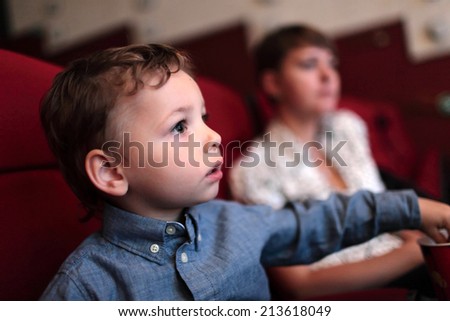 The kid has popcorn in the cinema