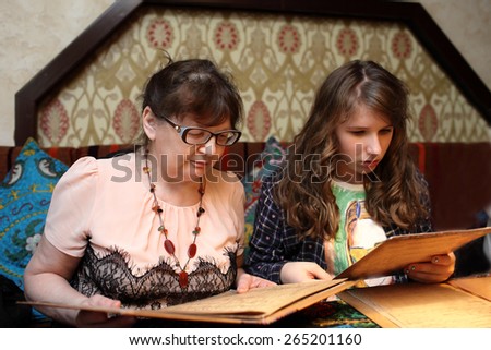 Grandma with grandchild looking menu in the restaurant