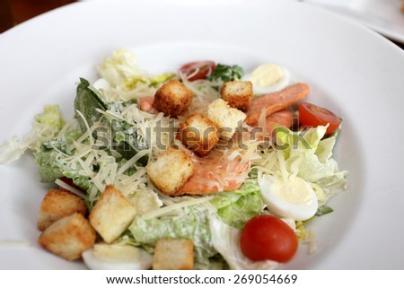 Caesar salad with fish on a white plate