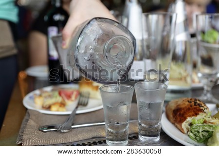Waiter pouring vodka from carafe in the russian restaurant