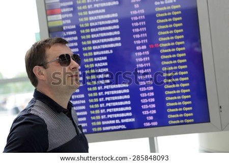 Person on the schedule of planes background in the airport