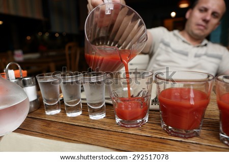 Man pouring tomato juice in the pub