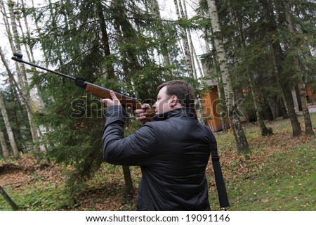 The man aiming a pneumatic air rifle