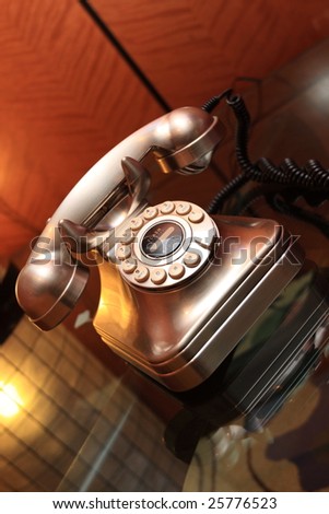 The metallic telephone on glass table in hotel