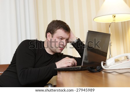 The man watches a film on laptop in a hotel