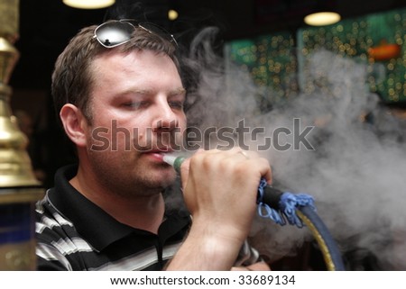 Smoking shisha man in a arabic hookah house