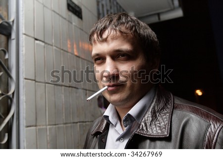 The smoking man in leather coat outdoor