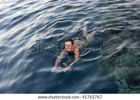 The swimming woman on Red sea in the evening