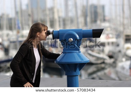 Young woman looks through telescope on city
