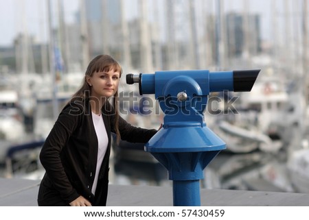 The young woman poses with telescope at summer