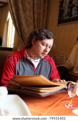The man reads menu at the restaurant