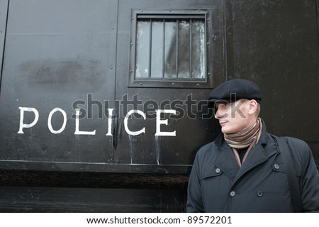 The man posing on the police carriage background
