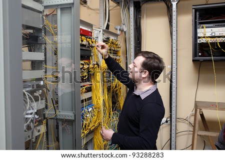 The network technician connecting fiber optic at server room
