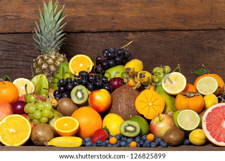 Fresh healthy fruit from whole and half fruit front of an old wooden wall