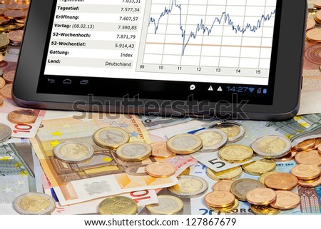 Stock index on Tablet PC with euro coins and bills