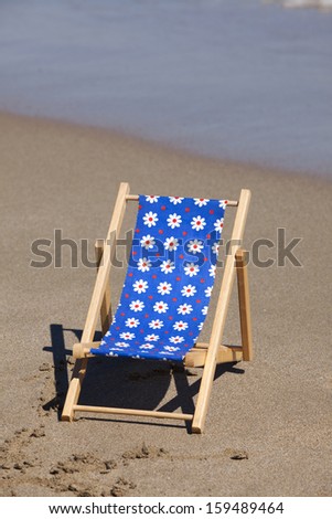 Beach scene in the Summer with a Sun Chair on the Beach with Copy Space in upper part of image