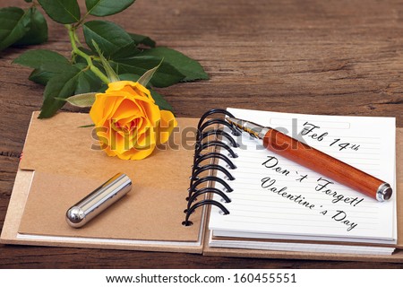 ValentineÂ´s Day Event Reminder with a Flower, Notepad with Pen on old Wooden Background