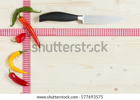 Fresh Hot Chili Peppers with a Kitchen Knife on a Wooden Board with Copy Space