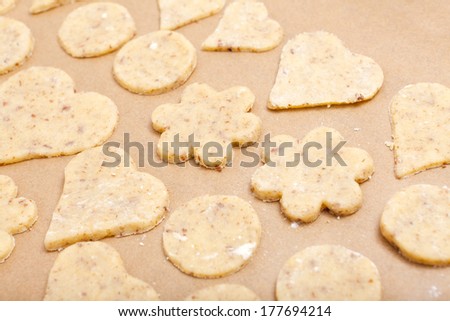 Cookie dough in different shapes on a baking sheet with parchment paper