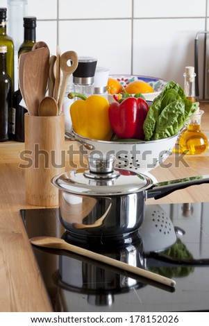 Cooking Pot and Cooking Spoon on Ceramic Hob and other Kitchen Utensils