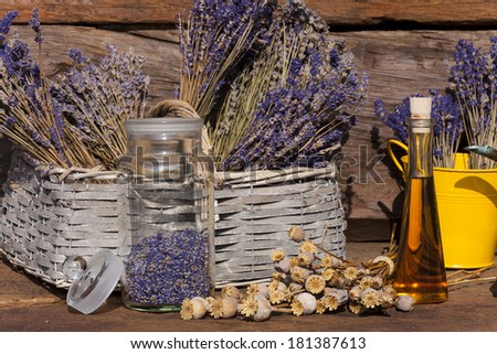 Dried lavender blossoms and poppy capsules on a table in front of a garden shed