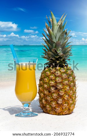 Pineapple and pineapple juice on the beach in the background of ocean