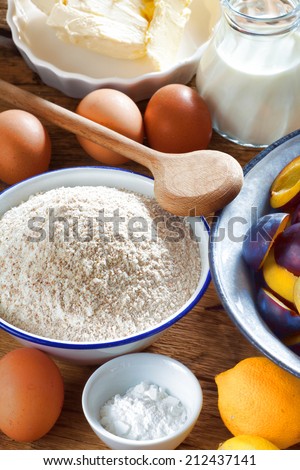 Many ingredients such as butter, flour, plums, baking powder and milk for crumble Plum Cake
