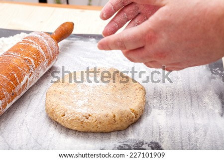 Roll out with wooden rolling pin the biscuit dough on the baking mat