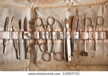 Set of old, vintage surgical instruments: scalpel, scissors,  clamp.