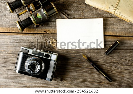 old traveling equipment: camera, binoculars, letters and postcard