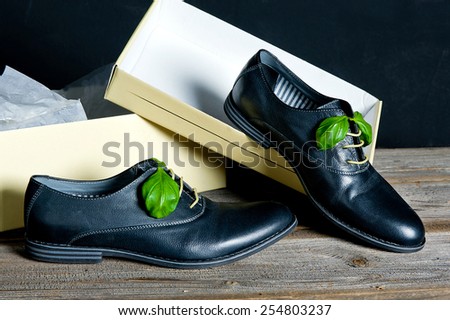 italian leather shoes concept: boots laced with spaghetti and basil leaf as bow in a box