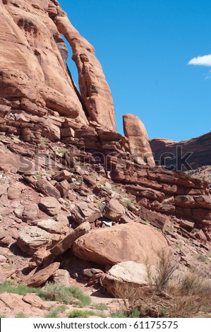 This vertical landscape features Jug Handle Arch, a popular feature accessed by Scenic Byway 179 between Moab and Potash, Utah on a sunny late summer afternoon in September.