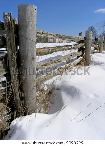 Wooden Fence-Vertical. Wooden Farm Fence during the sunny winter day after snowstorm. Picture is vertical orientated.