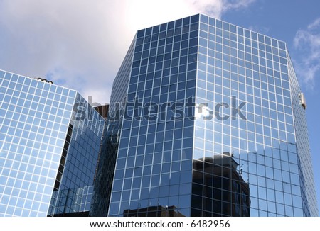Corporate America 02. The Office building which accommodate many companies offices and cover by clouds sky.
