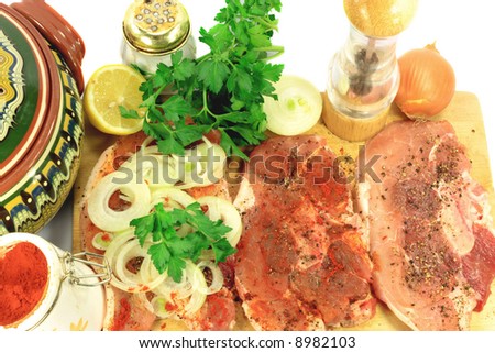 Old recipe for backed pork chops. Three stages of preparation of pork chops. Added lemon juice, black pepper, red paper. Covered with sliced onion and parsley baked in pottery pot.
