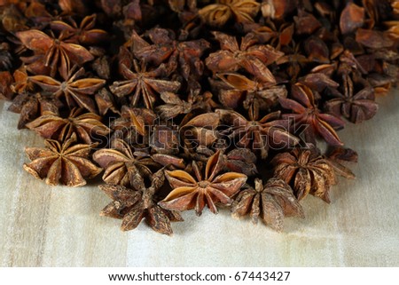 Still life picture of Star Anise on pail over wooden board.