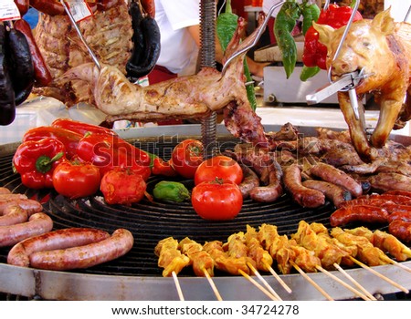rabbit, meat and vegetables in course of barbecue preparation at spring fair in Barcelona, Spain