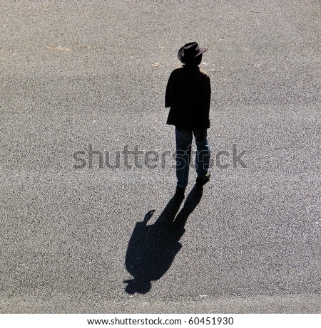 lonely man going on asphalt road